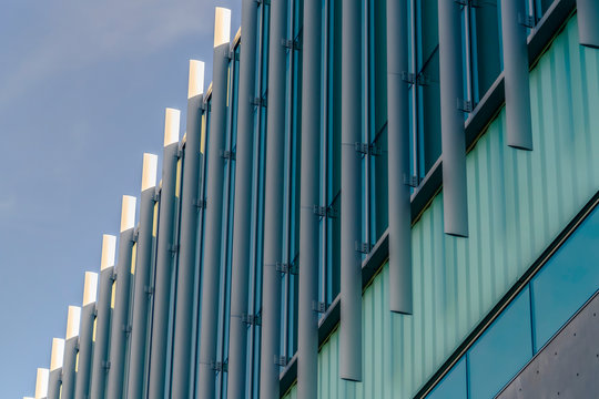 Exterior of a modern building with vertical sunshades outside the glass windows