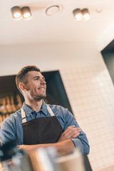 Fototapeta premium Cheerful barista looking into the distance and smiling