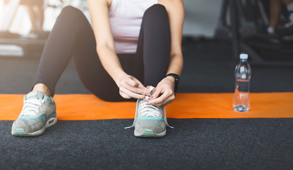 Ready for training. Woman tying laces preparing for workout