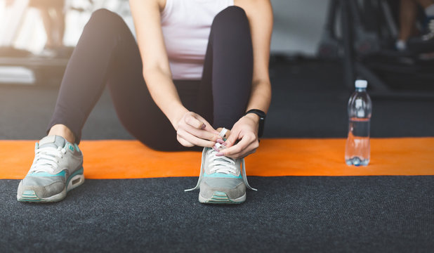 Ready for training. Woman tying laces preparing for workout