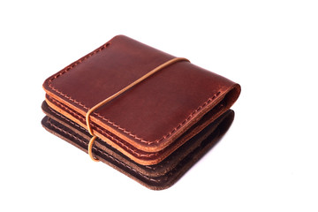 Handmade two red and brown leather cardholders with rubber band isolated on white background closeup. Stock photo of handmade luxury accessories.