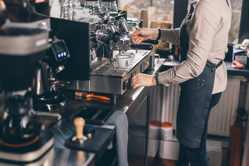 Barista making coffee in front of the espresso machine