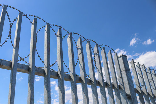 razor wire on a tall steel fence