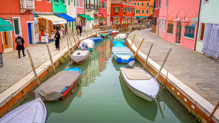 Fototapeta na wymiar VENICE, ITALY - NOVEMBER 11th: A canal runs through the colorful fishing village of Burano in Venice, Italy on November 11th, 2017