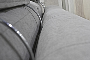 Detail of the back and headrests of the gray velour sofa.