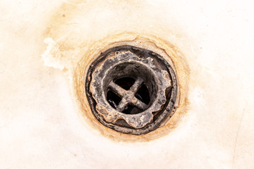 Extremely dirty bath drain mesh, hole covered with limescale or lime scale and rust close up,...