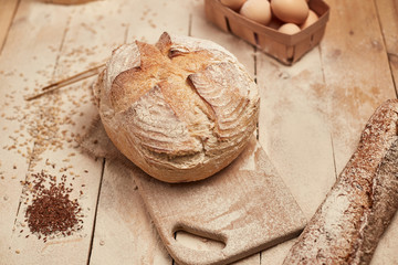 Loaf of bread on wooden background, food closeup. Bread at leaven. Unleavened bread.