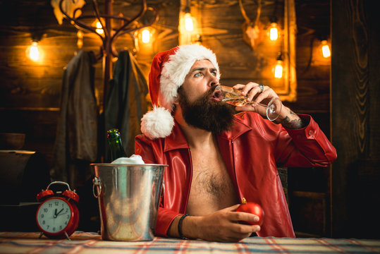 Alcohol drink. Happy new year. Manly brutal santa leather jacket. Brutal santa claus. Man bearded hipster santa with red hat celebrate with champagne drink. Christmas holiday. Lonely on christmas eve