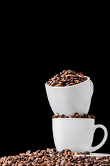 Black coffee in white cup and coffee beans on black background. Top view, space for text