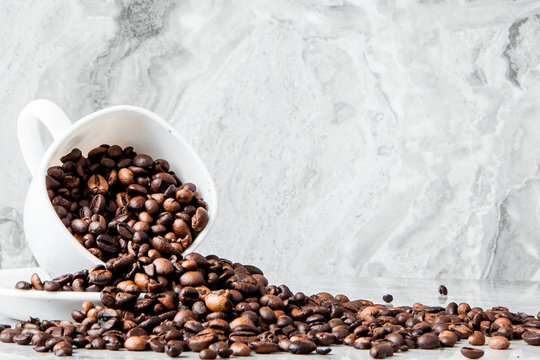 Black coffee in cup and coffee beans on marble background. Top view, space for text
