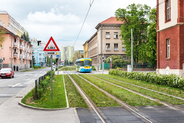 Colourful tram runs on tramway track over green grass area in Kosice (SLOVAKIA)