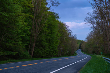 Fototapeta premium A snake -like route along the Harriman State Park, New York, featuring dramatic sky on the background