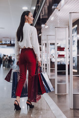 Cheerful young woman is shopping before flight