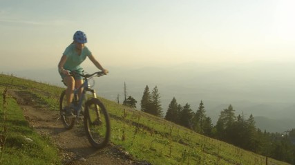 CLOSE UP: Four friends on mountain bicycles ride along a narrow mountain trail on a sunny spring morning. Group of active tourists go for a scenic bike ride in the picturesque Slovenian mountains.