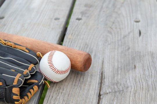 wide photo of baseball equipment. Glove, bat and ball on wooden background with room for text