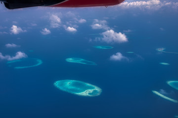 Plakat Dieses einzigartige Bild zeigt die Malediven, die von einem Flugzeug von oben fotografiert werden. Sie können die Atolle im Meer gut sehen.