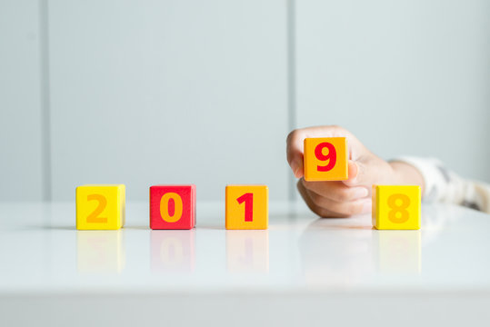 Concept of happy new year 2018 change to 2019,Hand women changing or putting a cube wood block - Powered by Adobe