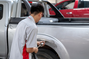 mechanic worker repair car body and paint with professional service with soft-focus and over light in the background