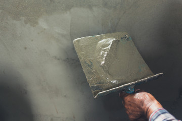 Plasterer renovating indoor walls.