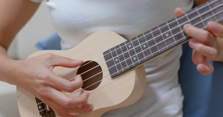 Woman play ukulele with a song