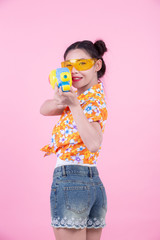 Happy girl holding a pink background water gun.