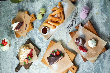 Assorted sweet desserts. Top view. Gray textured background. Beautiful serving dishes. Dessert. Food chain