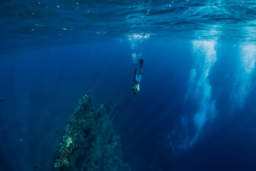 Freediver man dive underwater at shipwreck in Bali. Freediving in ocean