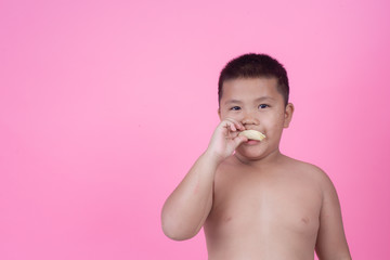 Obese boy who is overweight on a pink background.