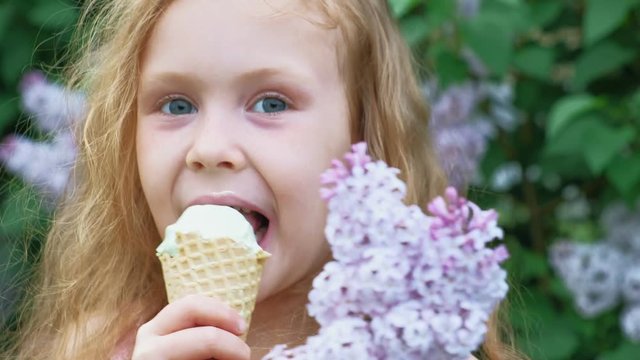 Little girl eats ice cream outdoors. Summer