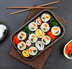 Set of kimbub or sushi roll in steel plate ready to serve in korean style menu with chopstick.