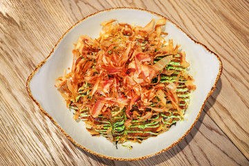Okonomiyaki. Japanese savory pancake, with noodles, cabbage, seafood. Dish from Japan. Famous street food.