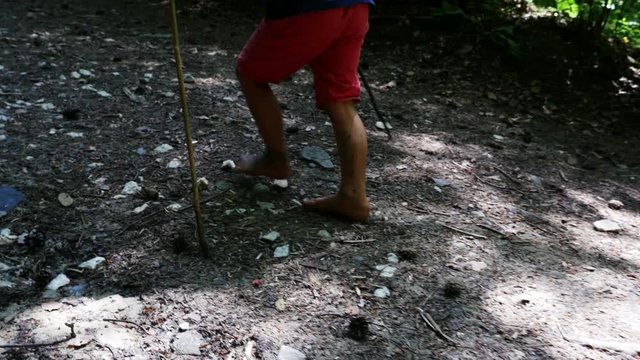 Little boy bare feet walking along a mountain muddy path, 4k