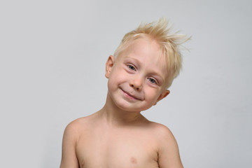 Little smiling blonde boy shirtless. Portrait. Space for text. White background