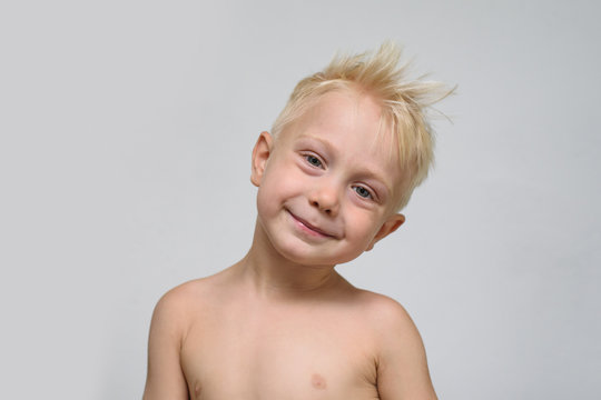 Little smiling blonde boy shirtless. Portrait. Space for text. White background