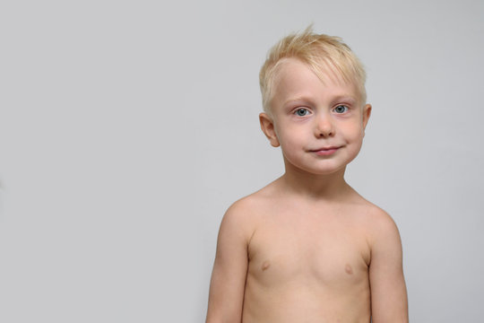 Cute smiling blonde boy shirtless. Portrait. Space for text. White background