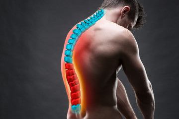 Pain in the spine, a man with backache, injury in the human back, chiropractic treatments concept