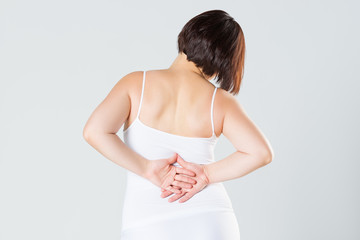 Back pain, kidney inflammation, ache in woman's body on gray background