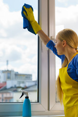 Woman cleaning window at home
