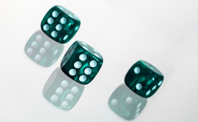 Three green casino dice with white slanted background