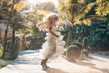 beautiful young cheerful fashion model in white dress having fun outdoors at sunset