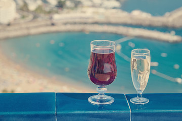 Flutes of wine are standing on the table against wonderful ocean background.