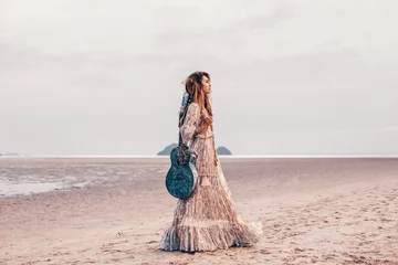 schönes junges modemodell im weißen kleid mit gitarre draußen bei sonnenuntergang © zolotareva_elina