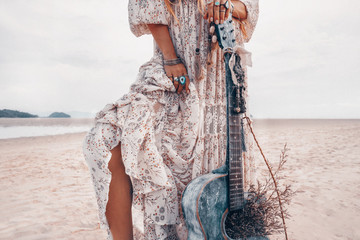close up of fashionable young woman legs. Fashion model with guitar outdoors at sunset © zolotareva_elina