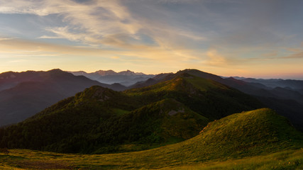 The mountains during a beautiful orange sunrise or sunset with clouds.
