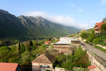 Top view of street of Mtskheta in morning. Tiled roofs, mountain and Kura River