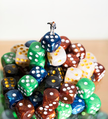 Miniature Photographer standing on mountain of colored dice