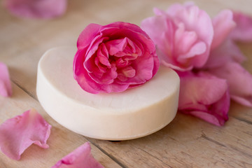 Obraz na płótnie Canvas White soap pink camellia flowers petals wooden table