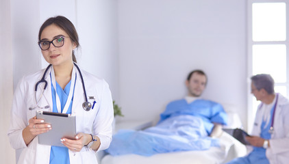 Fototapeta premium Doctor checking heart beat of patient in bed with stethoscope