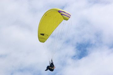 Paraglider flying yellow wing