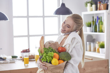 Young woman holding grocery shopping bag with vegetables Standi